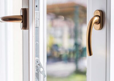 Fehér festett fa nyílászárók arany kilinccsel Rákospalotán