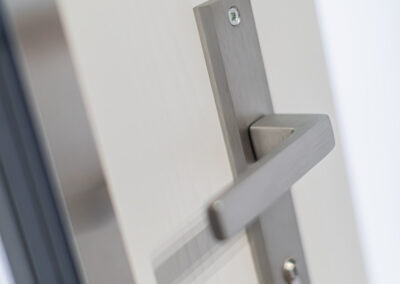 Acél Plus Wels bejárati ajtó kilincs és cilinder részlet Fóton, fehér ajtószárny