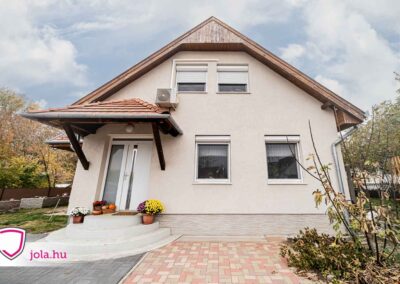 Acél Plus Wels bejárati ajtó fehér színben Fóton, modern homlokzatú háznál.