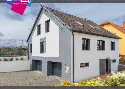 Antracit garázskapuk és ablakok modern házon Paks